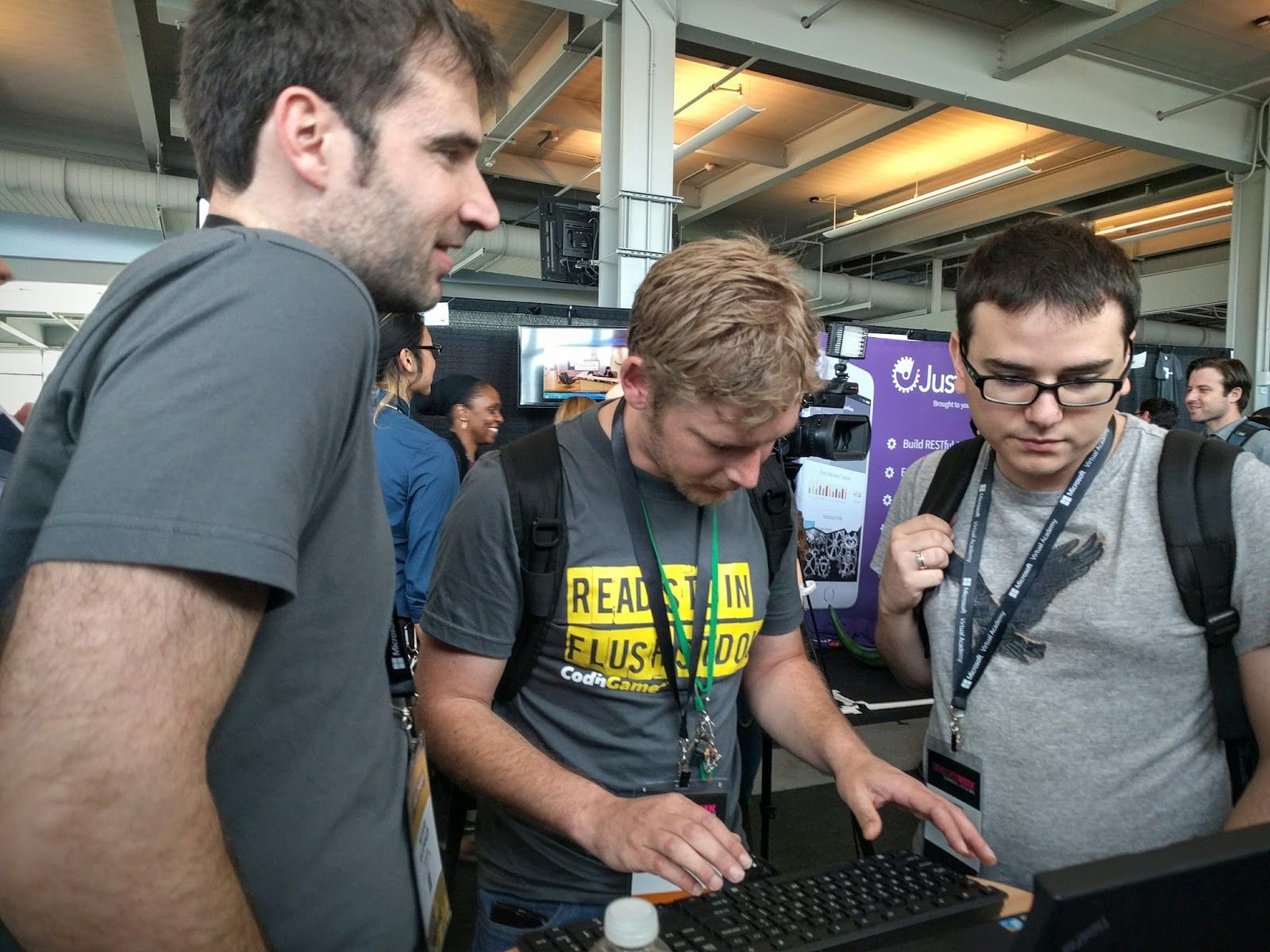 3 coders behind a laptop